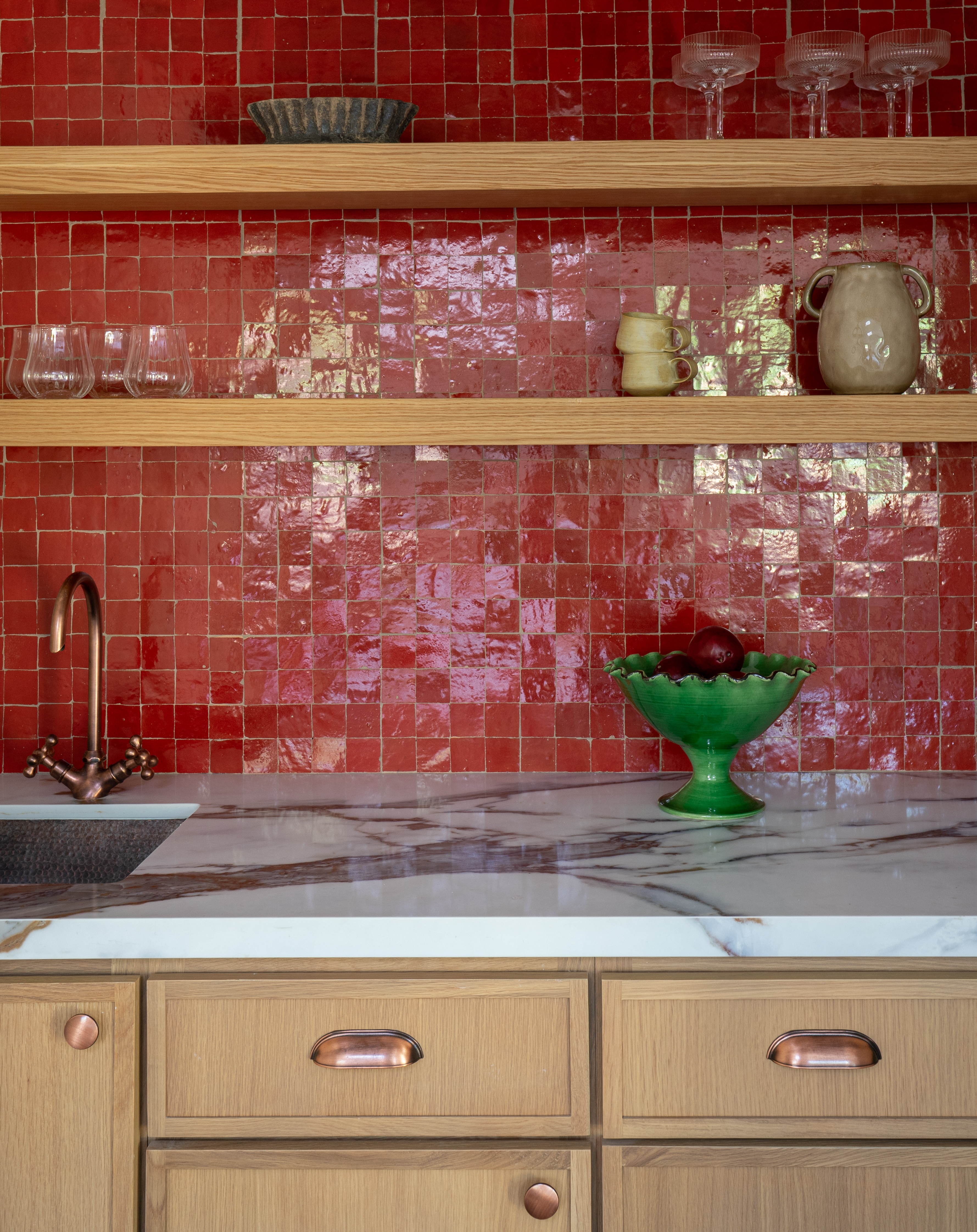 Casita kitchenette with bold red zellige tile backsplash, oak shelving, and veined marble counters in Palm Springs home