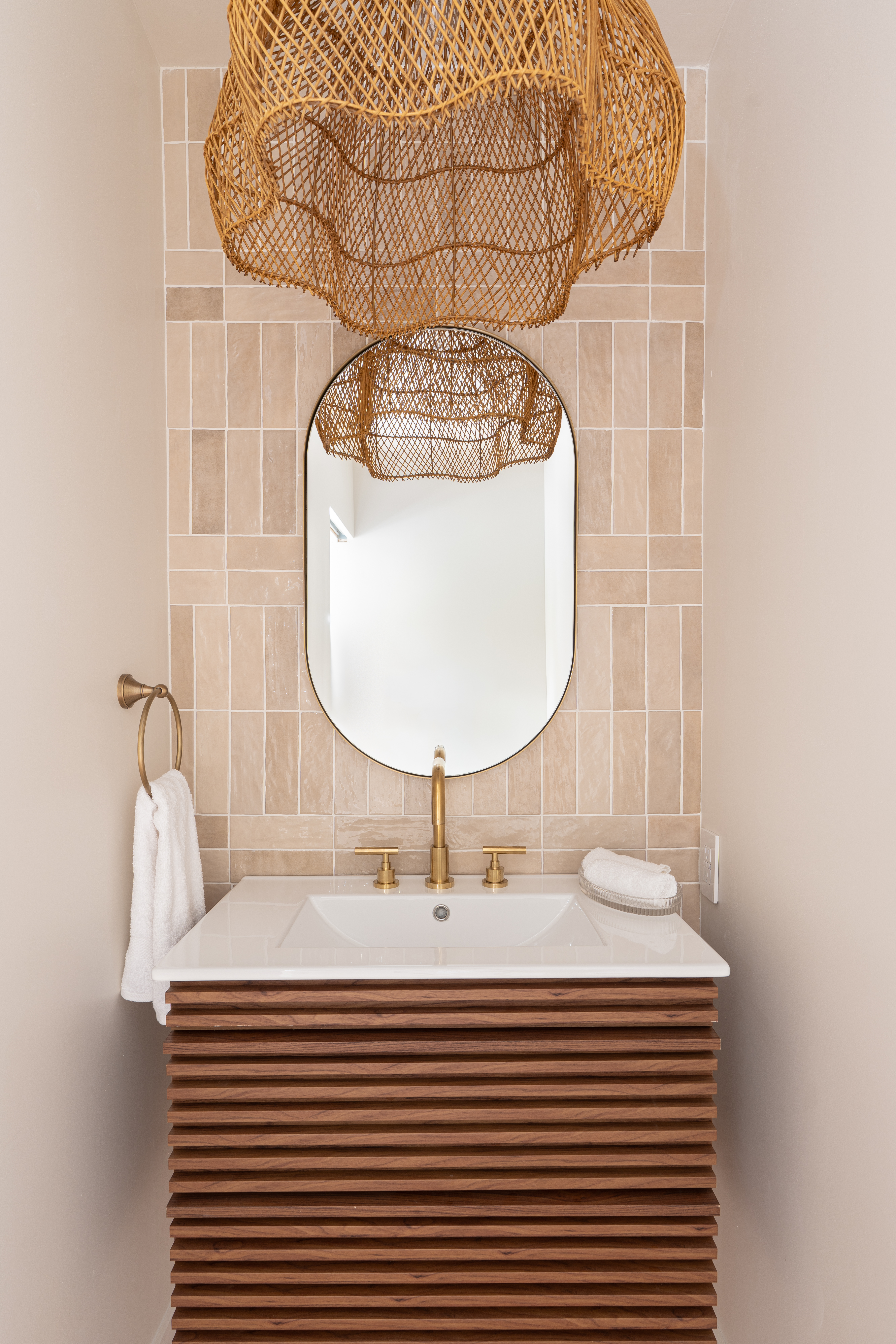 Powder room with blush zellige tile, woven pendant lights, and ribbed wood vanity in Palm Springs home