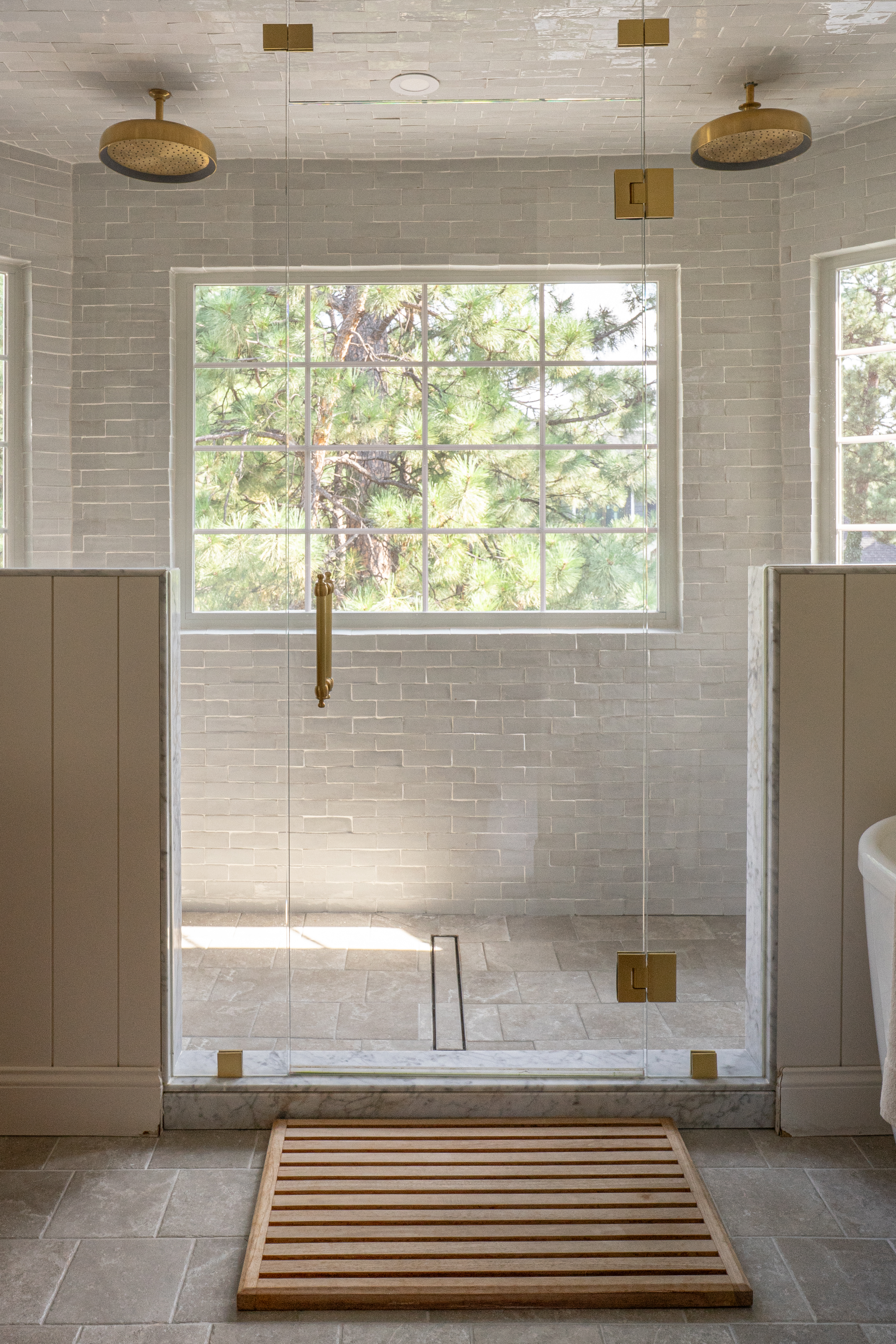 His-and-hers steam shower with off-white zellige tile to the ceiling and brass Kohler shower heads in Castle Pines primary bathroom