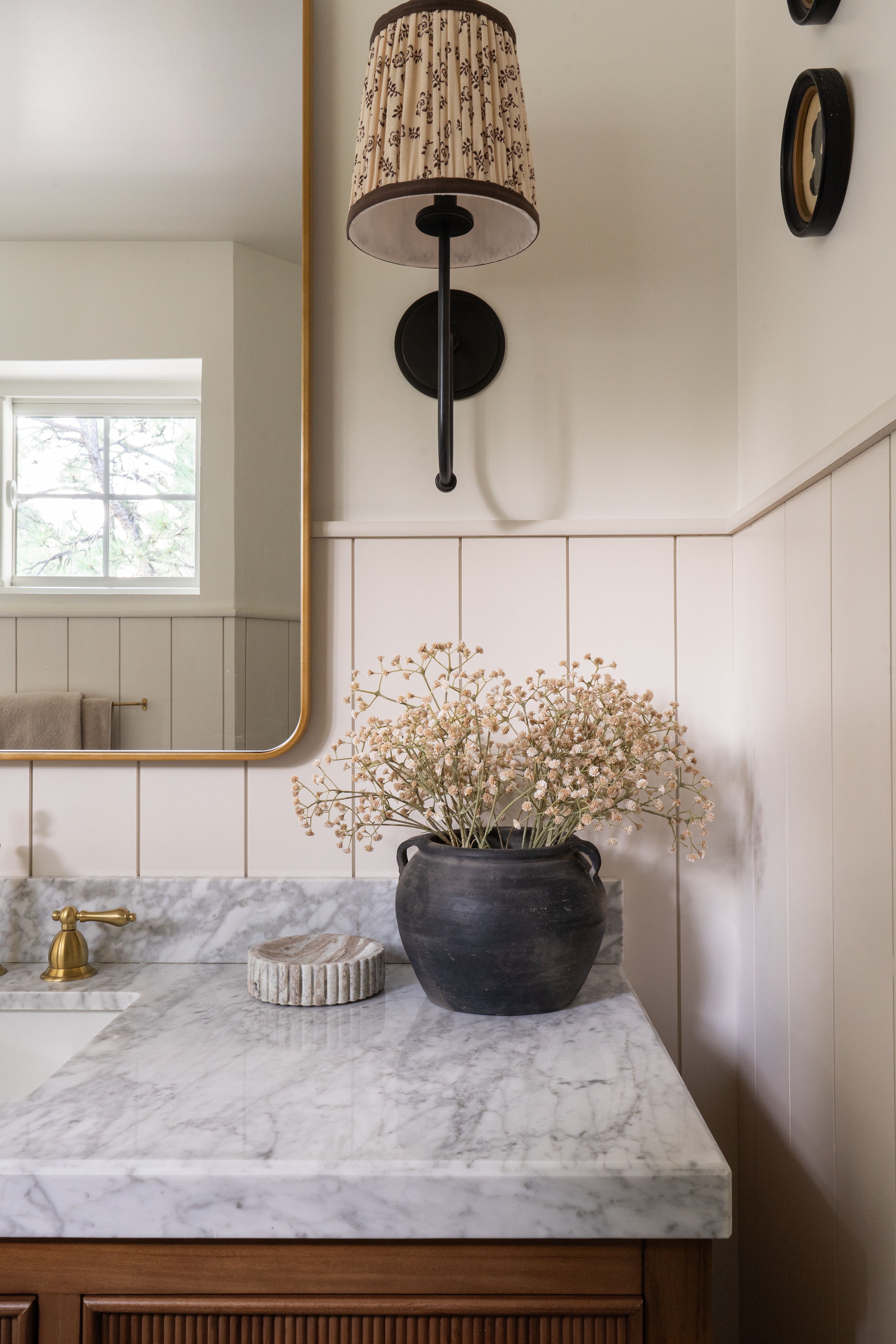 Close-up detail of marble counter, brass fixtures, and dried florals in Castle Pines primary bathroom